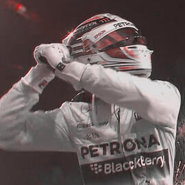 Lewis Hamilton celebrating a win, helmet on, both his hands clasped together up near his head as he cheers. There is a red tint to the photograph.